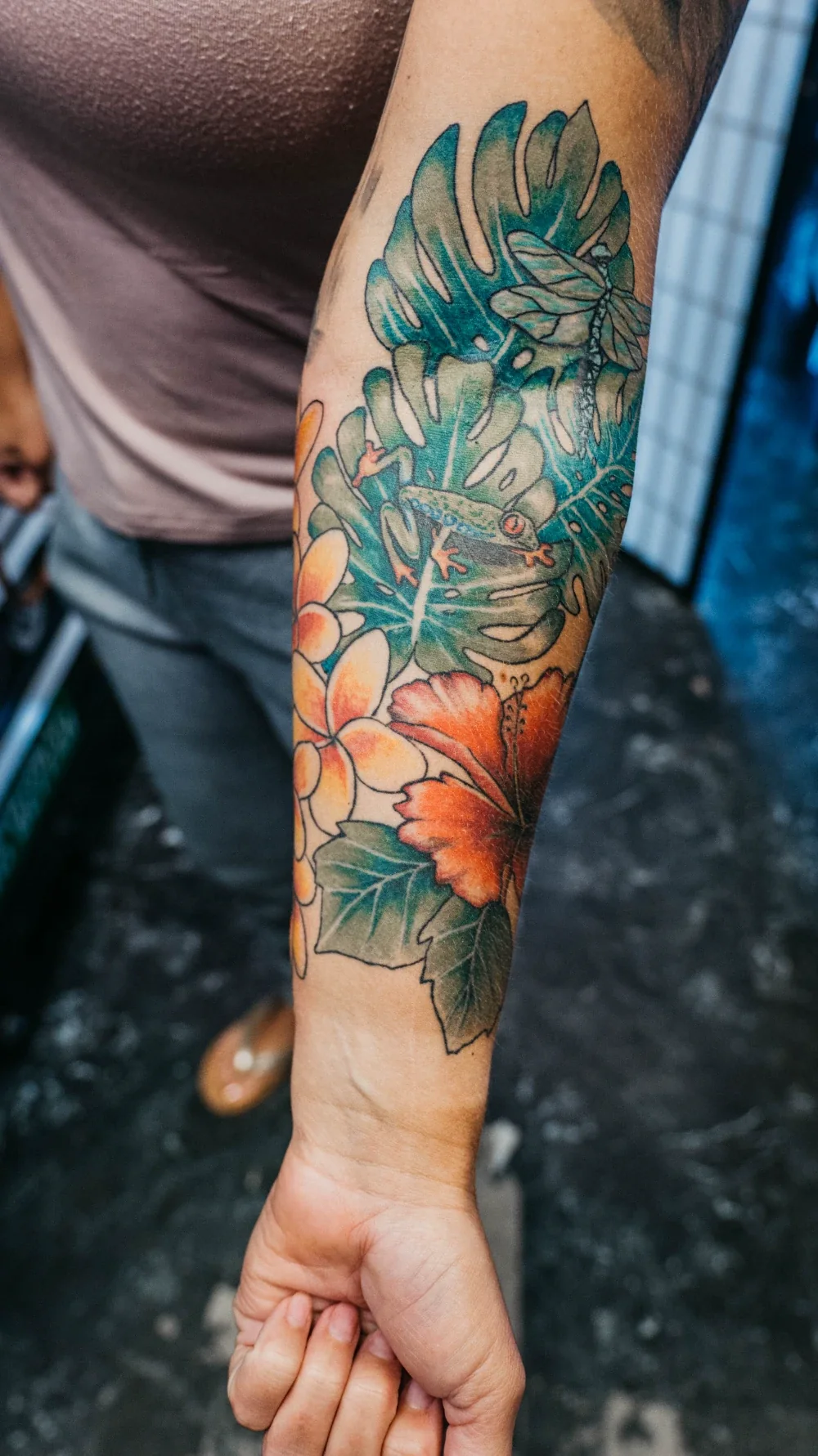 Colorful arm tattoo — frog and hibiscus